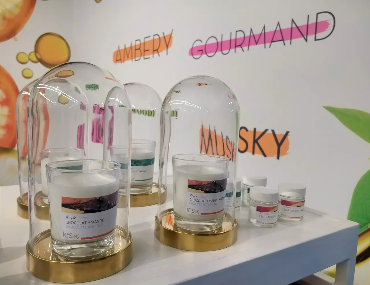 Glass domes displaying chocolate almond aromatic ingredients on gold stands - IES Ingredients stand
