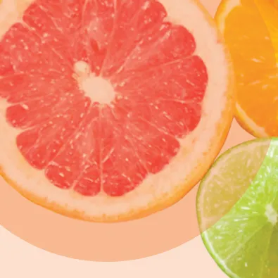 Tranches d'agrumes colorées - pamplemousse rose, orange et citron vert sur fond pastel