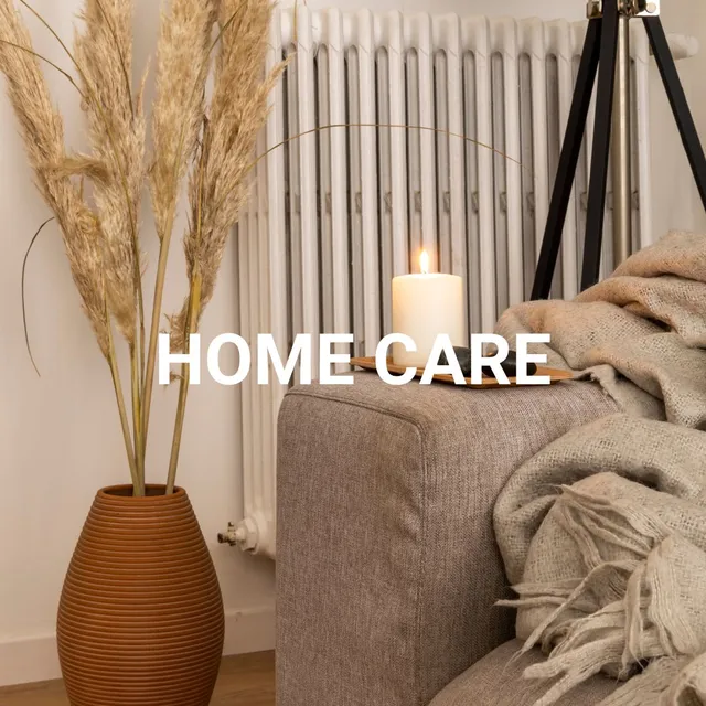 Salon cosy avec canapé beige, vase en rotin avec épis de blé, bougie allumée et radiateur blanc